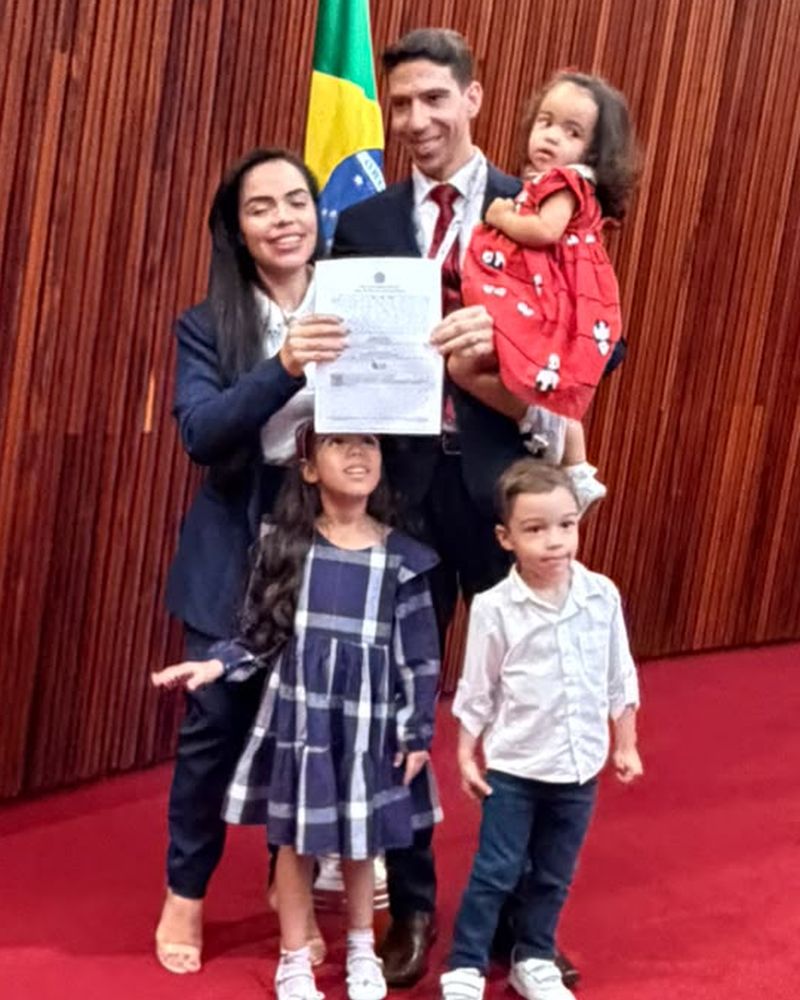 Erick Sudré com a esposa e os filhos segurando o termo de posse no TSE